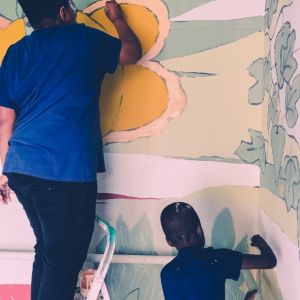 Ragazzo e bambino che dipingono una parete, laboratorio artistico espressivo