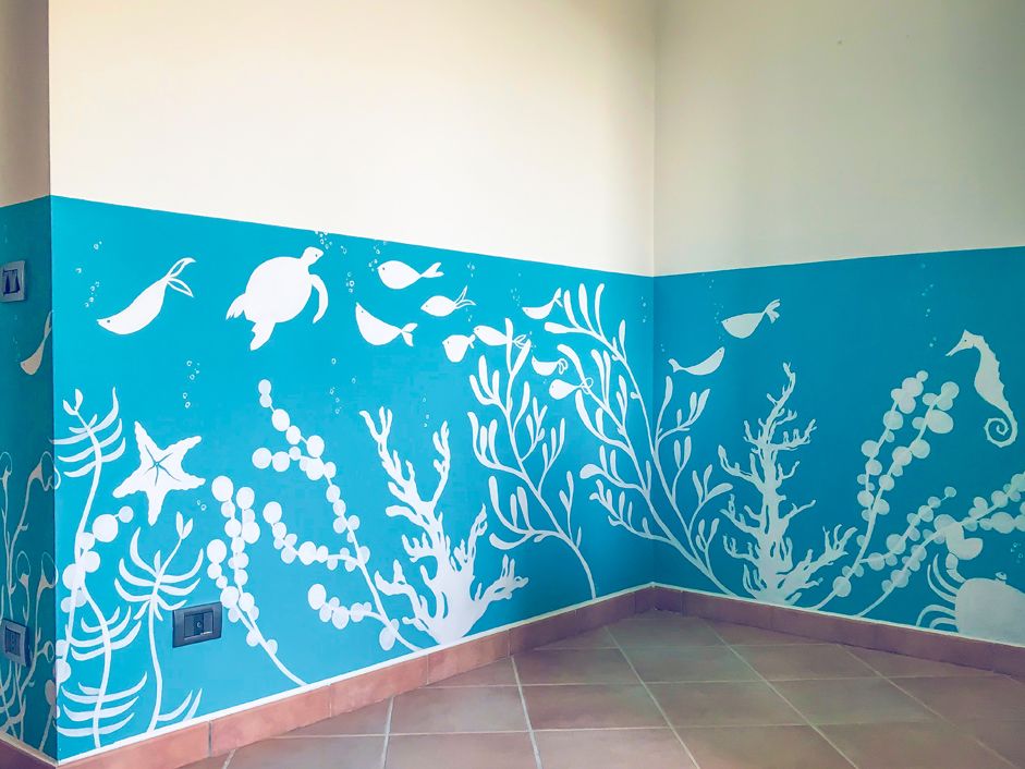 Decorazione a tema marittimo dipinta a mano su parete interna, pesci, tartaruga, cavalluccio marino e piante acquatiche dipinte di bianco su sfondo turchese