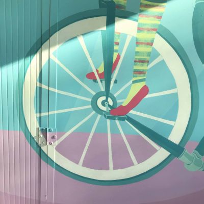 MagoMargo dalle scarpette magenta sulla bicicletta con un gatto, porta le stelle con la bacchetta magica, dipinto su parete con colori dalle tonalità vintage