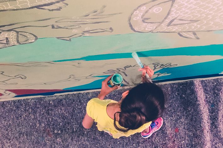 Laboratori artistico-espressivi. Bambina che dipinge su una parete