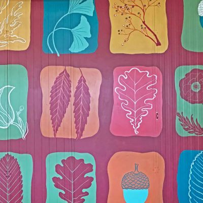 Fiori e foglie dipinti su parete, pattern dalle tonalità forti, rossi, gialli, turchese, verdi